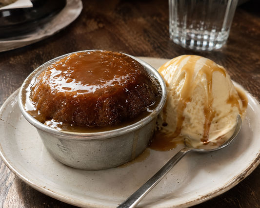 Caramel pudding with ice cream on a plate with a spoon