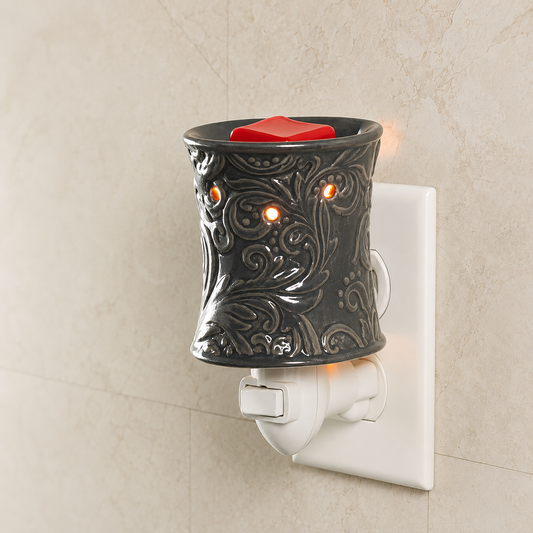 Decorative wall-mounted wax warmer with a red candle on a beige wall.